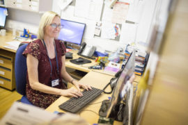 Lady wearing glasses at her desk