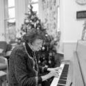 A black and white photo of Frances playing the piano at Christmas